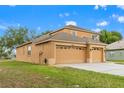 Charming two-story home featuring a large three-car garage, well-maintained lawn, and attractive neutral paint at 4335 Canongate Ct, Spring Hill, FL 34609