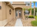 Close up of the inviting front door with decorative palm trees and easy access walkway with stone at 4335 Canongate Ct, Spring Hill, FL 34609
