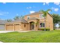 Spacious two-story home featuring a well-manicured lawn, three-car garage, and attractive front-yard landscaping at 4335 Canongate Ct, Spring Hill, FL 34609