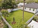 Expansive backyard with lush green lawn, bordered by a white fence, and mature trees at 461 Pent St, Tarpon Springs, FL 34689