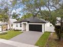 Single-story home with well-maintained lawn and driveway, complemented by mature trees at 461 Pent St, Tarpon Springs, FL 34689