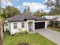 Beautiful single-story home with a black garage door, well-kept lawn, and charming landscaping at 461 Pent St, Tarpon Springs, FL 34689