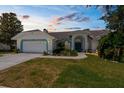 Charming single-story home with a well-manicured lawn, two-car garage, and a lovely blue trim at 473 Tournament Dr, Spring Hill, FL 34608