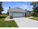 Charming single-story home with a well-manicured lawn, two-car garage, and a lovely blue trim at 473 Tournament Dr, Spring Hill, FL 34608