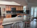 Open kitchen featuring granite countertops, stainless steel appliances, and a breakfast bar with seating at 5045 Musselshell Dr, New Port Richey, FL 34655