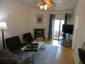 Comfortable living room with hardwood floors, a fireplace, and a sliding glass door leading to a balcony with great sunlight at 545 Walden Ct, Dunedin, FL 34698