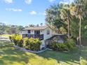 Exterior view of a two-story home featuring a balcony, a screened-in pool area, and beautiful green landscaping at 7101 N 18Th St, Tampa, FL 33610