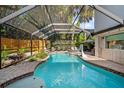 A lovely screened-in pool provides a refreshing escape with ample seating and lush greenery surrounding the area at 7101 N 18Th St, Tampa, FL 33610