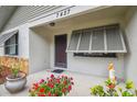 Inviting front porch with stone accents, potted plants, and a decorative pelican statue at 7427 Baltusrol Dr, New Port Richey, FL 34654