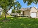 Well-manicured lawn surrounds this single-story home with lush landscaping and a two-car garage at 7427 Wimpole Dr # 7427, New Port Richey, FL 34655