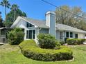 Charming single-story home featuring a well-manicured lawn and lush landscaping with palm trees at 7444 Candlelight Ct, New Port Richey, FL 34652