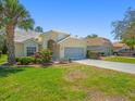 Charming single-story home with a well-manicured front yard, mature landscaping, and a two-car garage at 9398 Mississippi Run, Weeki Wachee, FL 34613