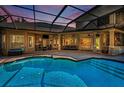 A stunning outdoor space features a sparkling pool, covered patio, and scenic views overlooking an outdoor fireplace at 10808 Alico Pass, New Port Richey, FL 34655