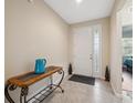 Inviting foyer with tile flooring and a decorative console table with a blue pitcher at 11254 Mollymawk Ct, New Port Richey, FL 34654