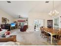 Spacious living room featuring a fireplace, neutral carpet, ceiling fan and pass through to the kitchen at 11536 Golden Rain Dr, New Port Richey, FL 34654