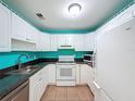 Functional kitchen featuring white cabinets, laminate countertops, and white appliances at 11648 Boynton Ln # 39Gb, New Port Richey, FL 34654