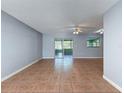 Spacious living room with tile flooring, neutral paint, and sliding glass doors to screened porch at 11648 Boynton Ln # 39Gb, New Port Richey, FL 34654