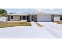 Inviting single-story home with a manicured lawn, stone accents, and a concrete driveway at 1216 Yawl Way, Venice, FL 34285