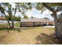 Fenced backyard featuring mature trees and a well-maintained lawn at 13100 Fish Cove Dr, Spring Hill, FL 34609