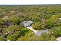 An aerial view of a large home with a private pool surrounded by dense, mature trees at 18663 Autumn Lake Blvd, Hudson, FL 34667