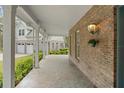 Spacious covered porch featuring tile floors, brick siding, and column supports at 3431 Saturn Rd, Brooksville, FL 34604