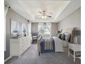 Serene bedroom featuring a tray ceiling, ceiling fan, and plush carpeting at 4321 High Ridge Ave, Spring Hill, FL 34609