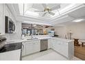 Bright kitchen featuring white cabinets, stainless steel appliances, and a ceiling fan at 4504 Dewey Dr, New Port Richey, FL 34652