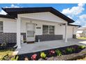 Inviting front porch featuring black brickwork, a horseshoe decoration, and a well-manicured garden at 4607 Kennedy Dr, New Port Richey, FL 34652
