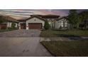 Beautiful home featuring a paver driveway, meticulously kept lawn, and a tile roof at 5070 Night Star Trl, Odessa, FL 33556