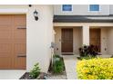 Townhome entrance with covered porch, featuring a decorative front door and manicured landscaping at 5383 Companion Ln, Tampa, FL 33619