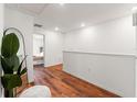 Upstairs hallway featuring wood floors, white walls, and stylish decorations at 5383 Companion Ln, Tampa, FL 33619