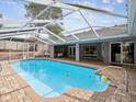 Inviting screened-in pool area with a covered lanai, creating the perfect space for outdoor relaxation and entertainment at 5411 Joyner Ave, Spring Hill, FL 34608