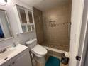 The remodeled bathroom with a tiled shower, safety bar, and modern toilet offers style and accessibility at 5736 Colonial Dr, New Port Richey, FL 34653