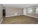 Bright living room featuring wood floors, a large window, and neutral paint at 6206 11Th Ave, New Port Richey, FL 34653
