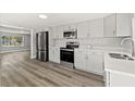 Modern kitchen featuring stainless steel appliances, ample counter space, and stylish gray cabinetry at 6418 E 23Rd Ave, Tampa, FL 33619