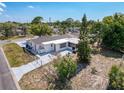 Aerial view of backyard featuring a concrete patio, fenced yard, and mature landscaping at 6431 Gainsboro Dr, Port Richey, FL 34668