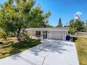 Charming single-story home boasts a brick facade, spacious driveway, and a well-manicured lawn at 6431 Gainsboro Dr, Port Richey, FL 34668