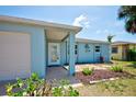 Inviting front porch with a white front door, well-landscaped garden, and attached one-car garage at 6432 Boatyard Dr, Hudson, FL 34667