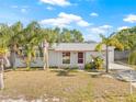Inviting single-story home with a well-maintained lawn, mature palm trees, and a welcoming entrance at 7365 Pinehurst Dr, Spring Hill, FL 34606