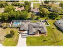 Beautiful aerial view featuring a main home, a guest house, a screened in pool, and a large driveway at 7466 Jonquil Pl, Weeki Wachee, FL 34607