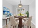 Cozy dining area with modern chandelier, a painting, a plant and a glass door leading to outside at 7466 Jonquil Pl, Weeki Wachee, FL 34607