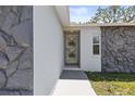 Close up of front entrance with charming decorative door and rock facade at 8240 Gulf Way, Hudson, FL 34667