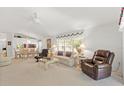 Open-concept living area with living room, dining area, and a ceiling fan with neutral carpet and walls at 1013 Sweet Jasmine Dr, Trinity, FL 34655