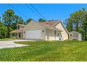 Rear exterior view of the home featuring an attached garage and a separate storage shed in the backyard at 10540 Noddy Tern Rd, Weeki Wachee, FL 34613