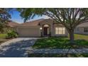 Charming single-story home features a well-maintained lawn, two-car garage, and inviting front entrance at 1082 Nodding Shade Dr, Brooksville, FL 34604
