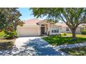 Charming single-story home features a well-maintained lawn, two-car garage, and inviting front entrance at 1082 Nodding Shade Dr, Brooksville, FL 34604