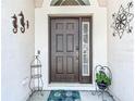 Inviting front entrance with a decorative door, charming decorations, and a welcoming mat at 1082 Nodding Shade Dr, Brooksville, FL 34604