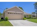 Spacious two-car garage, complemented by a well-manicured lawn and lush landscaping at 11310 Limpkin Rd, Weeki Wachee, FL 34614