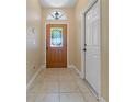 Inviting tiled entryway with decorative glass front door and white trim at 1171 Dartford Dr, Tarpon Springs, FL 34688