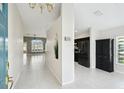 Bright, open foyer with neutral tile flooring, high ceilings, and views into the kitchen and living area at 11732 Wheatfield Loop, Hudson, FL 34667